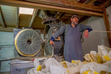 Quito, Ekvator - 23 Kasım 2016: un kapalı Quito şehir içinde bulunan üretmek için yapılan eski bir taş değirmeni fabrikasında çalışan kimliği belirsiz erkeğin