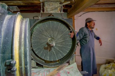 Quito, Ekvator - 23 Kasım 2016: un kapalı Quito şehir içinde bulunan üretmek için yapılan eski bir taş değirmeni fabrikasında çalışan kimliği belirsiz erkeğin