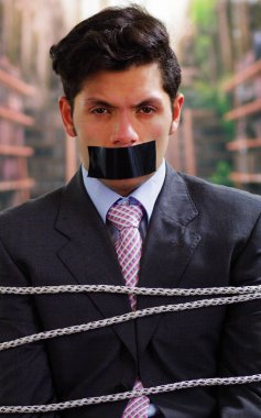 Arka plan bulanık içinde onun ağız içinde siyah bant ile işadamı ip, sandalyeyle tuzak