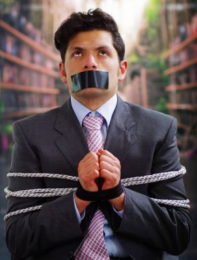 Siyah bir bant içinde onun ağız ve arka plan bulanık elinde ile işadamı ip, sandalyeyle tuzak