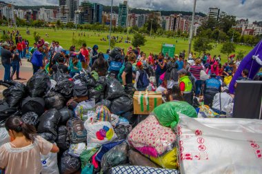 Quito, Ekvator - Nisan, 17, 2016: Deprem ve ağır makine Quito, Ekvator içinde felaket Temizleme tarafından yok ev arayan insanların kalabalık