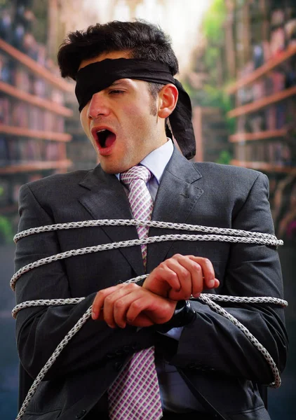 İp, başının arka plan bulanık içinde etrafında siyah bandana ile sandalyeyle işadamı tuzak