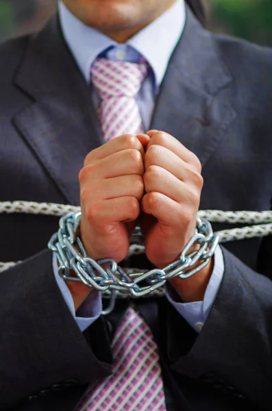 Acercamiento de un hombre de negocios con cadenas en las manos, en un fondo borroso — Foto de Stock