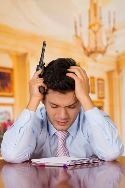 Depressed man with pistol gun wants to commit suicide, inside a house room, room background — Stock Photo, Image