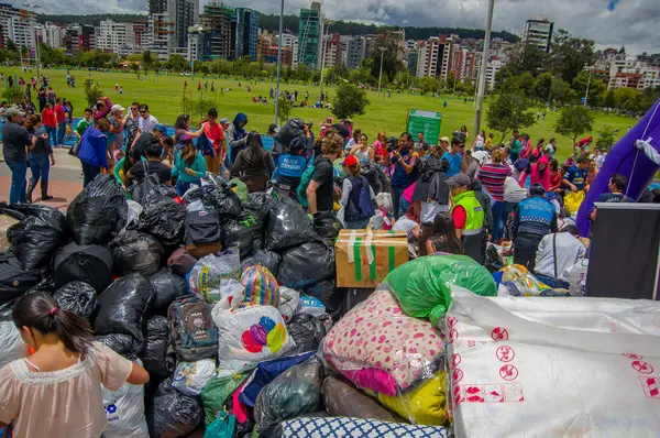 Quito, Ekvator - Nisan, 17, 2016: Deprem ve ağır makine Quito, Ekvator içinde felaket Temizleme tarafından yok ev arayan insanların kalabalık