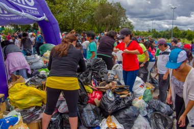 Quito, Ekvator - Nisan, 17, 2016: Afet Yardım gıda, giyim, ilaç ve su kıyılarında deprem kurtulanlar için sağlayan kimliği belirsiz kişi Quito