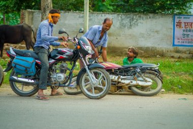 Agra, Hindistan - 19 Eylül, M 2017: diğer erkek arkadaşı yardım ederken kimliği belirsiz bir motosiklet o etmeleri onun motosiklet, Agra, Hindistan merkezi Hindistan'da sokaklarda dan sürmek