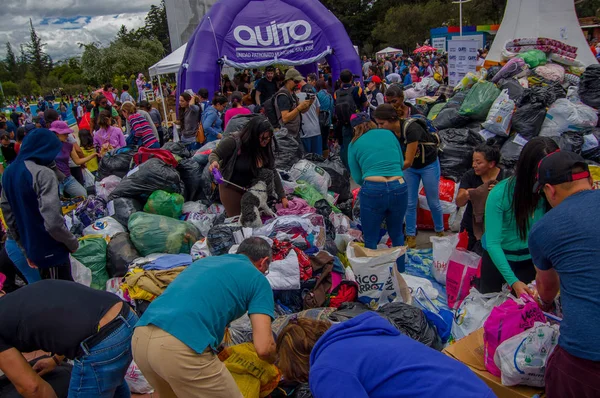 Quito, Ekvator - Nisan, 17, 2016: Kalabalık sahil deprem ölüm için Afet Yardım gıda, giyim, ilaç ve su sağlayan insan Quito