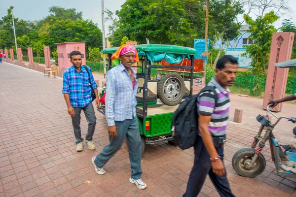 AGRA, INDIA - 19 DE SEPTIEMBRE DE 2017: Un hombre no identificado caminando cerca de una parada de motocicleta, en las calles del centro de la India en Agra, India — Foto de Stock