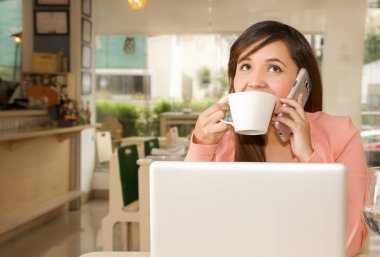 Çalışma ve o cep telefonunu arama yapmak için kullanırken kahve içme bir genç güzel iş kadını yakın çekim. İş kavramı