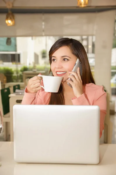 Nahaufnahme einer jungen schönen Geschäftsfrau, die arbeitet und Kaffee trinkt, während sie mit ihrem Handy telefoniert. Geschäftskonzept — Stockfoto