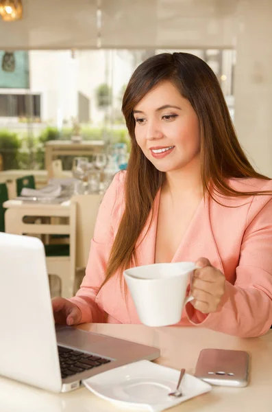 Nahaufnahme einer jungen schönen lächelnden Geschäftsfrau, die arbeitet und mit einer Hand eine Tasse Kaffee hält. Geschäftskonzept — Stockfoto