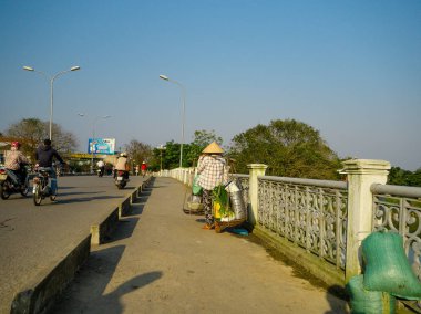 Hue, Vietnam - 13 Eylül 2017: köprüyü geçtikten ve omuzlarını içinde Hue, Vietnam yemekleri taşıyan kimliği belirsiz bir kadın