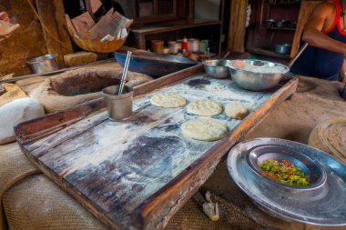 Jaipur, Hindistan - 20 Eylül 2017: Hint Gıda Mutfak Jaipur, Hindistan yanlarında, bazı malzeme ile ahşap bir masa üzerinde yemek kimliği belirsiz adam