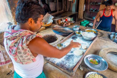 Jaipur, Hindistan - 20 Eylül 2017: Hint Gıda Mutfak Jaipur, Hindistan yanlarında, bazı malzeme ile ahşap bir masa üzerinde yemek kimliği belirsiz iki kişi