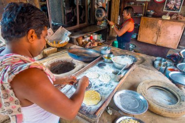 Jaipur, Hindistan - 20 Eylül 2017: Hint Gıda Mutfak Jaipur, Hindistan yanlarında, bazı malzeme ile ahşap bir masa üzerinde yemek kimliği belirsiz iki kişi