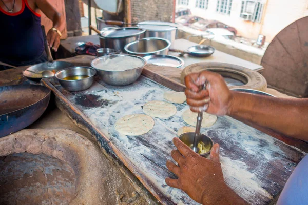 Hombre cocinando comida india sobre una mesa de madera en una cocina en Jaipur, India —  Fotos de Stock