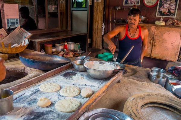 Τζαϊπούρ, Ινδία - 20 Σεπτεμβρίου 2017: Αγνώστων στοιχείων άντρας μαγείρεμα Ινδικό φαγητό για πάνω από ένα ξύλινο τραπέζι με κάποιο υλικό δίπλα τους, σε κουζίνα στη Τζαϊπούρ, Ινδία — Φωτογραφία Αρχείου