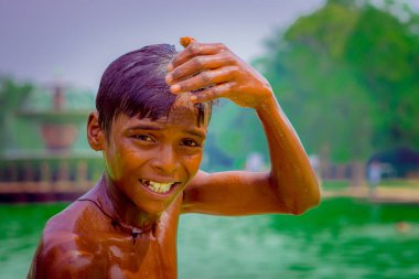 Delhi, Hindistan - 16 Eylül 2017: Portre kadar başını eliyle dokunmaktan ve kamera Delhi'deki bakarak kimliği belirsiz gülümseyen Hintli çocuk
