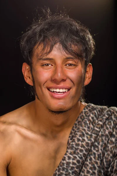 Close up of funny prehistoric man smiling to the camera in a black background — Stock Photo, Image