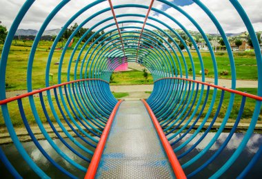 Kapalı bir yapay göl üzerinde renkli köprü görünümünü bir park orta içinde bulunan suda Cayambe'de şehir yansıması ile Ekvator