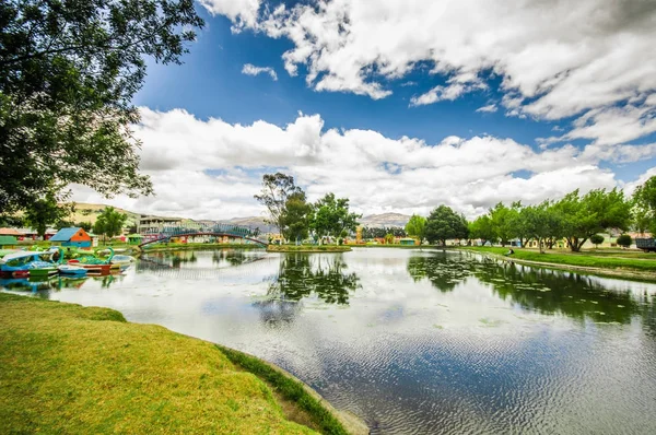 Beautiful day of an artificial lake located in the midle of a park, with the reflection in the water, in the city of Cayambe, Ecuador — Stock Photo, Image
