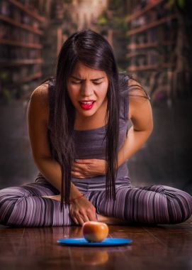 Arka plan bulanık içinde mavi bir plaka üzerinde bir elma baktığı zaman midesi acı acı anorexy acı güzel ve yalnız kız