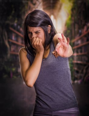 Arka plan bulanık çikolata kokusu yok için anorexy acı, bir parça çikolata onun elinde tutan ve burnunu kapsayan güzel ve yalnız kız