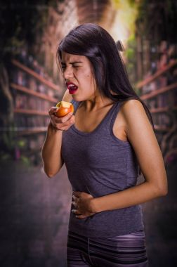 Bulanık bir arka planda bir elma yiyor iken onun midesinde acı acı anorexy, güzel ve yalnız kız