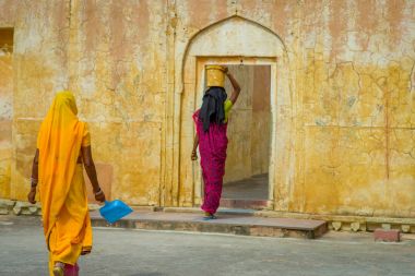 Amber, Hindistan - 19 Eylül 2017: Amber, Hindistan sokaklarında Amber Fort şehirde içinde yürüyor iken ain kafasını bir sepet kimliği belirsiz kadın