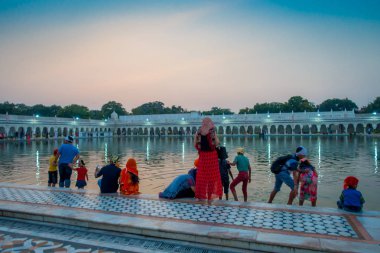 Delhi, Hindistan - 19 Eylül 2017: yüzme ve kafalarında şanslı olarak ünlü Sih gurdwara altın tapınak Harmandir Sahib Hindistan gölette yıkama tanımlanamayan kişi