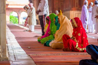 Delhi, Hindistan - 27 Eylül 2017: yerde oturan ve tapınağın Delhi içinde Jama Mescidi camide dua hijab giyen kadınların tanımlanamayan grubunun yakın çekim