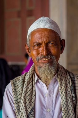 Delhi, Hindistan - 27 Eylül 2017: Kamera arka plan bulanık Jama Mescidi Camii Delhi, Hindistan tapınakta içinde bakarak beyaz sakallı bir adam portresi
