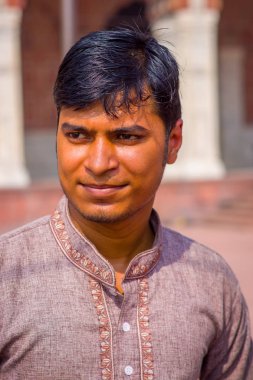 Delhi, Hindistan - 27 Eylül 2017: Kamera arka plan bulanık Jama Mescidi Camii Delhi, Hindistan tapınakta içinde bakarak yakışıklı bir adam portresi