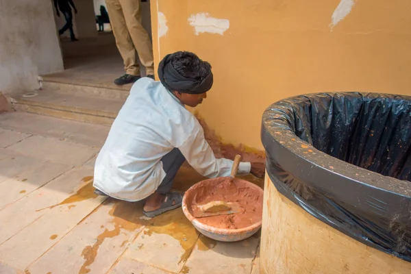 Amber, Indie - 19 września 2017: Niezidentyfikowany Indian man noszenie biały t-shirt i Spodnie szare, praca z gliną, rozwiązywanie problemów ściana jest miasto bursztynu, Indie — Zdjęcie stockowe