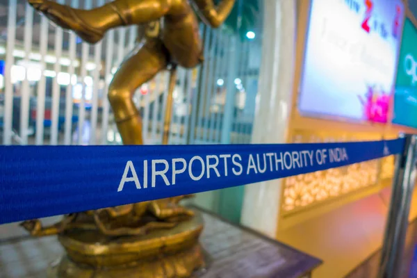 DELHI, INDIA - SEPTEMBER 19, 2017: Informative sign in white words over a blue band inside of the the International Airport of Delhi and crowd, Indira Gandhi International Airport is the 32th busiest — Stock Photo, Image