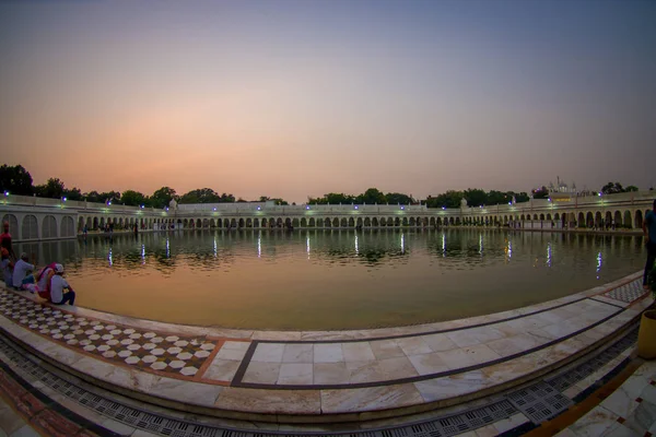 Delhi, India - 19 September 2017: Vacker solnedgång i berömda Sikh gurdwara gyllene templet centralhelgedom Sahib återspeglas i den konstgjorda dammen i Indien — Stockfoto