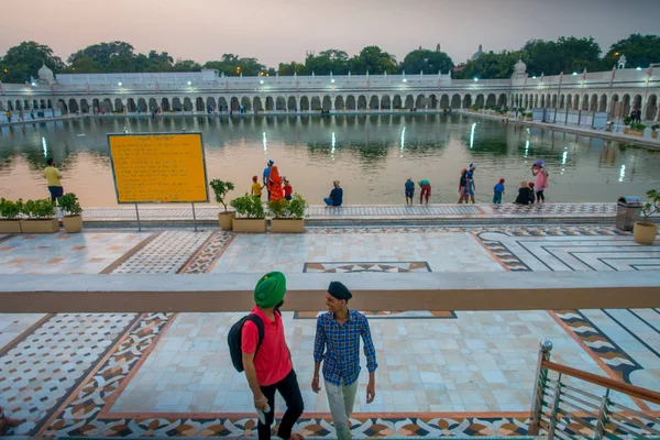 デリー, インド - 2017 年 9 月 19 日: 不明の人が歩いて階段を上ると dowstairs、他は水泳と有名な Sikh gurdwara 黄金寺院の池に幸運として頭を洗浄中 — ストック写真