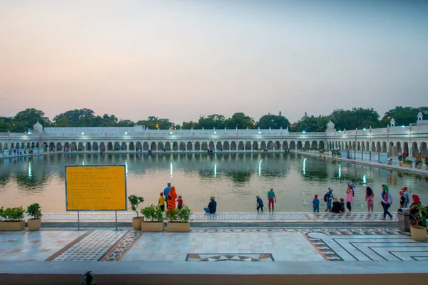 Delhi, India - 19 September 2017: Niet-geïdentificeerde mensen zwemmen en wassen hun hoofden als geluk in de vijver in de beroemde Sikh gurdwara gouden tempel Harmandir Sahib in India — Stockfoto