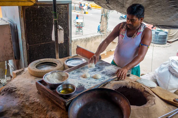 Jaipur, India - 20 settembre 2017: Uomo non identificato che impasta la massa di un cibo indiano su un tavolo di legno con del materiale accanto, in cucina a Jaipur, India — Foto Stock
