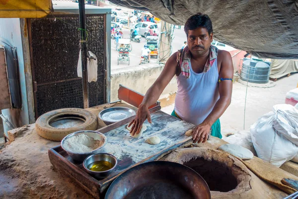 Jaipur, Hindistan - 20 Eylül 2017: Jaipur, Hindistan mutfakta yanlarında, bazı malzemeli ahşap bir masa üzerinde bir Hint yemeği kitle yoğurma kimliği belirsiz adam