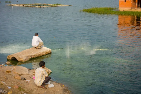 JAIPUR, INDIA - SEPTEMBER 20, 2017: Unidentified men enjoying in the border of the lake the beautiful Jal Mahal Water Palace on Man Sagar Lake in Jaipur, Rajasthan, India — Stock Photo, Image