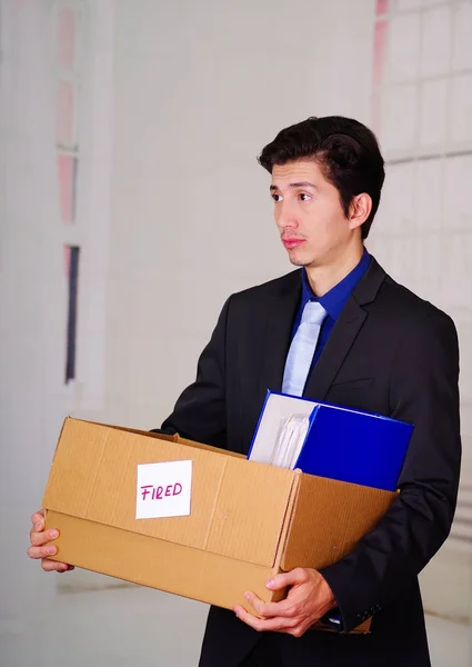 Close up de homem triste segurando uma caixa depois de ser demitido de seu trabalho em um fundo turvo — Fotografia de Stock