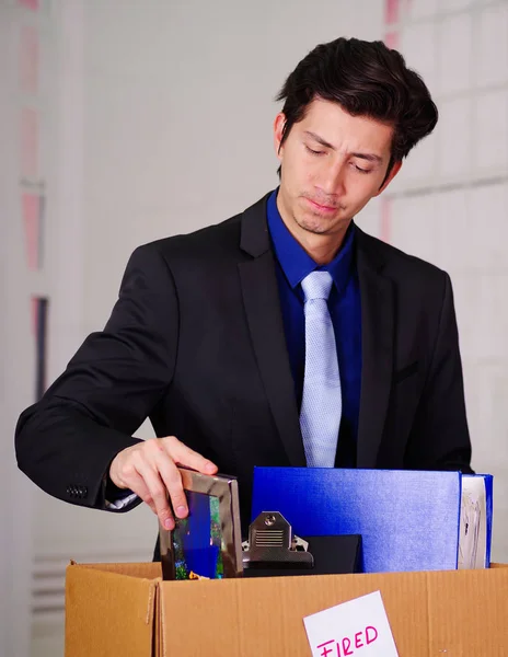 Nahaufnahme eines besorgten Mannes, der seine Habseligkeiten packt, nachdem er vor verschwommenem Hintergrund von seinem Job gefeuert wurde — Stockfoto