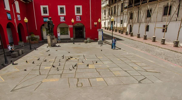 QUITO, ECUADOR - SEPTEMBER 10, 2017: Unidentified people walking in a plaza near of some pigeons, and view of colonial houses located in the city of Quito — Stock Photo, Image