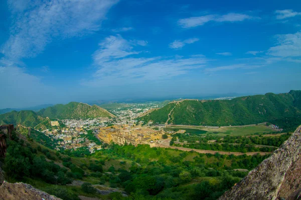 Bela paisagem de Amber Fort com árvores verdes, montanhas e pequenas casas perto de Jaipur em Rajasthan, Índia. Amber Fort é a principal atração turística na área de Jaipur — Fotografia de Stock