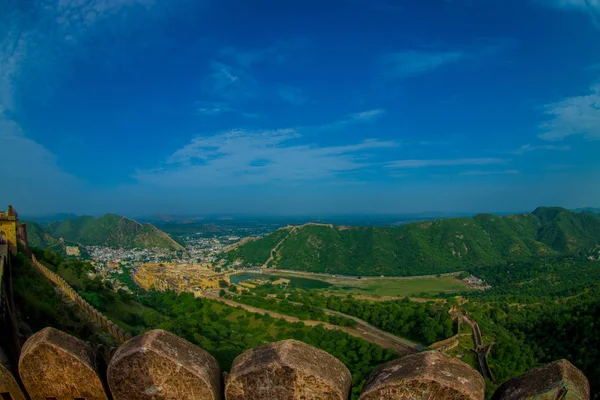 Bela paisagem de Amber Fort com árvores verdes, montanhas e pequenas casas perto de Jaipur em Rajasthan, Índia. Amber Fort é a principal atração turística na área de Jaipur — Fotografia de Stock