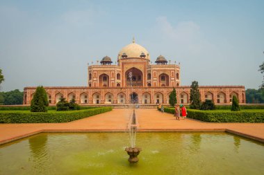 Delhi, Hindistan - 19 Eylül 2017: Yeni Delhi, Hindistan Moğol Kral Humayuns mezarlık önünde yapay bir çeşme ile önünde yürüyüş tanımlanamayan kişi