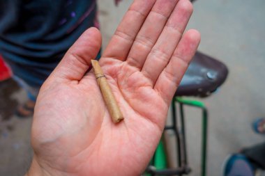 Delhi, Hindistan - 25 Eylül 2017: bir adamın sigarayla yaprak sarılı el yapımı, Paharganj yeni delhi Hindistan sokaklarında el kapat