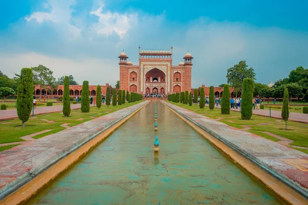 Agra, India - 20 de septiembre de 2017: Personas no identificadas caminando por el jardín cerca de Taj mahal a la entrada de la Gran Puerta en Darwaza-i rauza, con un estanque artificial en el medio, entrada principal a —  Fotos de Stock